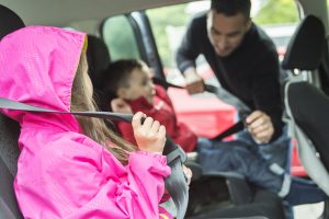 Minori sul sedile posteriore dell'auto con cinture di sicurezza