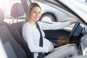 Donna incinta guida l'auto con cintura di sicurezza
