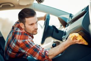 Un ragazzo pulisce gli interni della sua auto