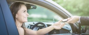 Una ragaza prende le chiavi dell'auto che ha noleggiato a lungo termine