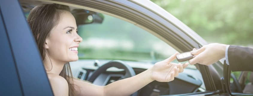 Una ragaza prende le chiavi dell'auto che ha noleggiato a lungo termine