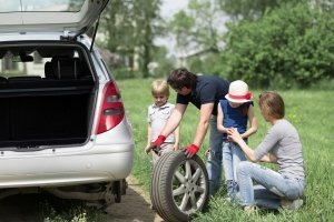 Papà cambia gomma bucata dell'auto insieme alla famiglia