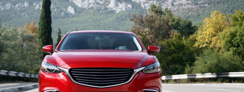 Auto rossa viaggia lungo la strada