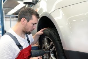 Un gommista installa un nuovo treno di gomme su un'auto