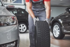 Un gommista sta per montare uno pneumatico sull'auto