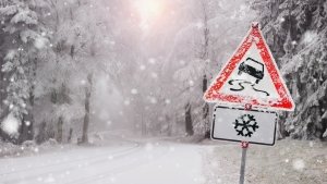 Strada innevata con cartello per auto in transito sulla neve